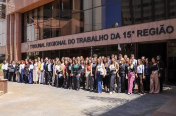 estudantes posam para foto em pé, em frente a sede do TRT-15