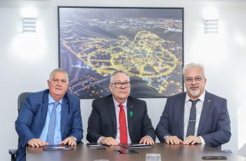 Três homens sentados à mesa