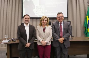 dois homens e uma mulher posam em pé para foto