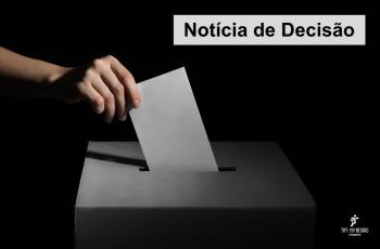*ParaTodosVerem: uma mão coloca um papel branco em uma urna