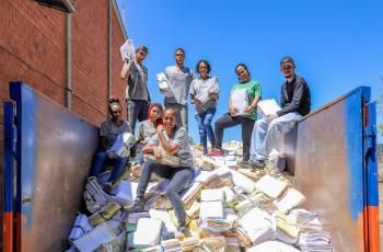 #ParaTodosVerem: pessoas posam para foto sobre uma pilha de processos