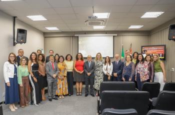 Grupo de pessoas posa em pé para foto