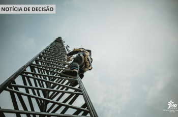 A imagem mostra uma torre e um homem subindo nela.