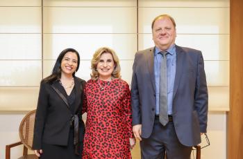 Três pessoas posam para a foto, duas mulheres e um homem.