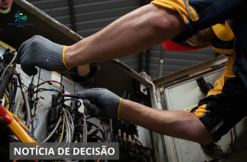 Imagem retrata a mão de uma pessoa mexendo na rede elétrica.