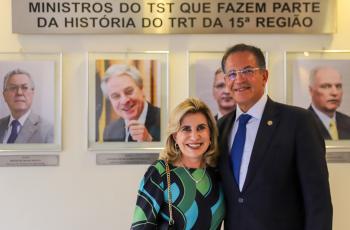 Dra. Ana Paula e ministro Campbell posa para foto em frente a galeria de ministros oriundos do TRT-15