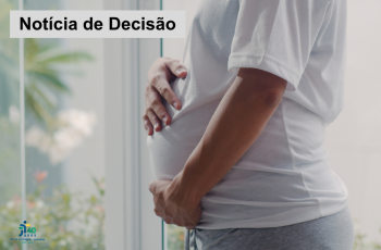 imagem parcial e lateral de uma gestante de camiseta branca e calça de malha cinza com as mãos na barriga