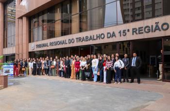 Grupo de pessoas posam para foto na frente do TRT-15.