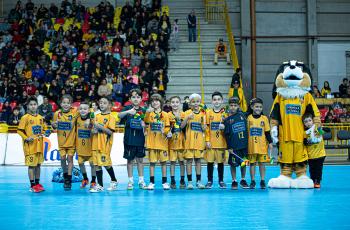 foto das crianças do futsal em quadra segurando o cata-vento alusivo ao combate ao trabalho infantil
