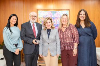foto posada da Dra. Ana Paula com Luiz Costa segurando a medalha, acompanhados de Karina as advogadas Marcela e Simone