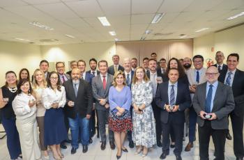 foto posada com os membros da alta administração e os juízes segurando as moedas