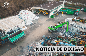 Fotografia aérea de uma unidade de triagem e processamento de materiais recicláveis. O local possui galpões, contêineres e grandes volumes de materiais separados e acumulados. Máquinas e caminhões estão distribuídos pelo pátio, com destaque para equipamentos utilizados no manejo dos resíduos. No canto superior esquerdo, aparece a identificação “TRT da 15ª Região – Campinas – 1986–2026”. Na parte inferior direita, há uma faixa com a inscrição “NOTÍCIA DE DECISÃO”.