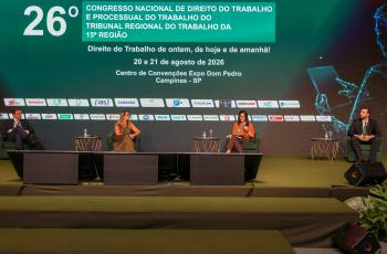 palestrantes em suas poltronas no palco, com telão temático do congresso em tom de verde ao fundo