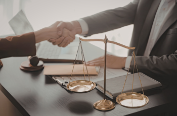 imagem de duas pessoas apertando as mãos e de uma balança da justiça ao lado