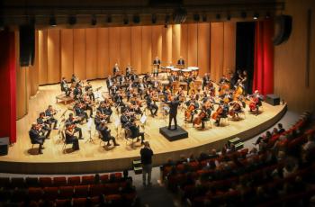 Uma orquestra se apresenta no palco do teatro.