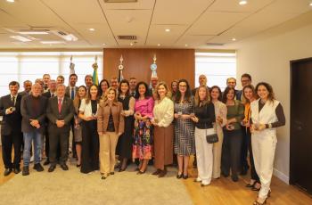 Magistrados posam para a foto cada um segurando sua moeda.