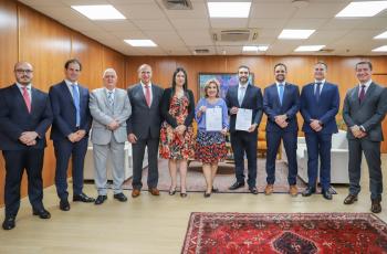 participantes de pé com Dra. Ana Paula e Jefferson Nurbegovic segurando o termo assinado