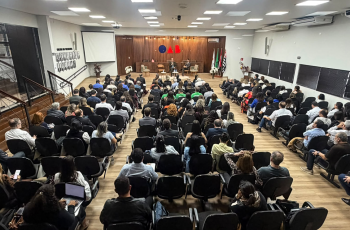 foto do auditório lotado com as autoridades na mesa de trabalhos ao fundo